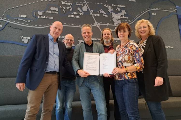 6 mensen staan in de hal van het gemeentehuis van Geldermalsen en laten een ondertekend convenant zien