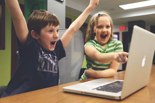 twee kinderen wijzen naar een laptopscherm