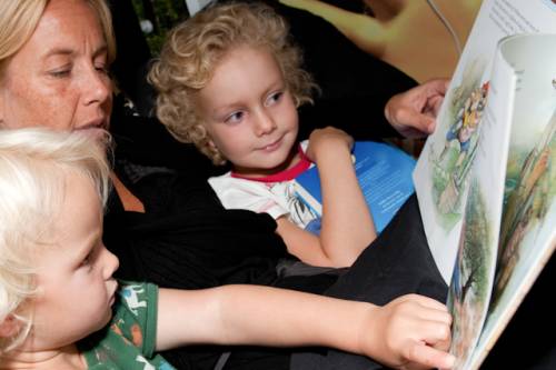 Een vrouw leest 2 peuters voor