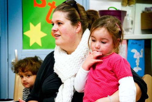 Een moeder met twee kinderen naast zich.