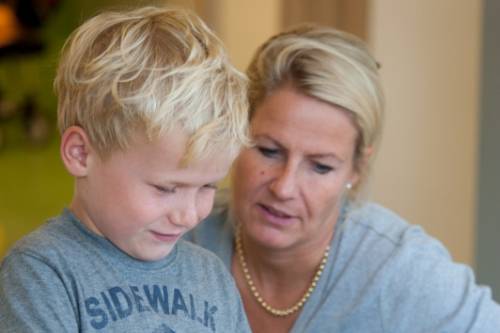 Moeder en zoon kijken samen naar een boekje