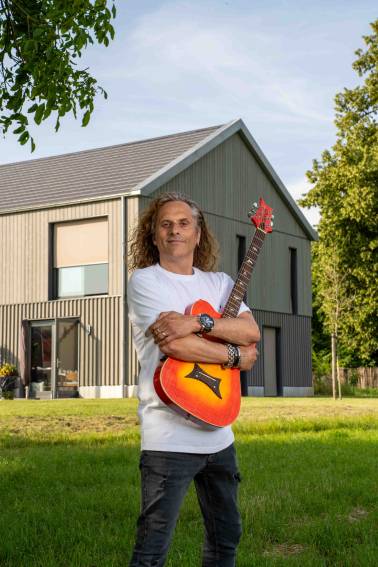 Guido Frissen met gitaat in zijn tuin