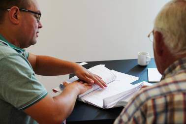 Twee mensen buigen zich samen over administratief papierwerk