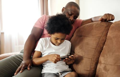 Jongen en vader kijken op smartphone