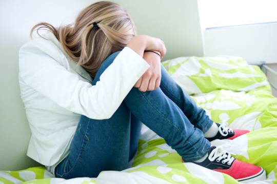 Meisje zit met hoofd naar beneden