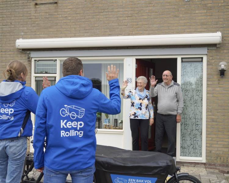 Een ouder echtpaar zwaait bij de voordeur twee medewerkers van Keep Rolling uit.