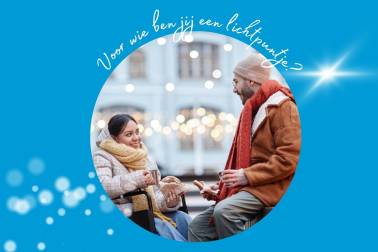 Een jonge vrouw in een rolstoel en een jonge man, beiden in dikke winterkleding, eten samen buiten een broodje.