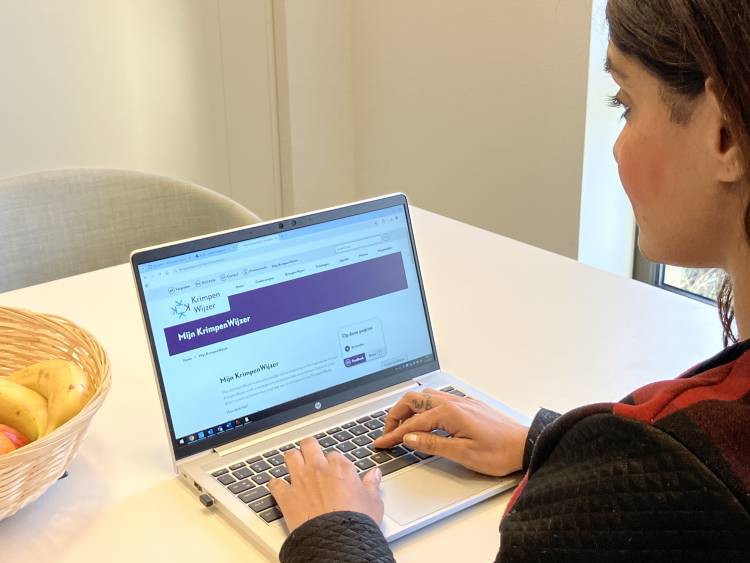 Vrouw achter laptop met Mijn KrimpenWijzer