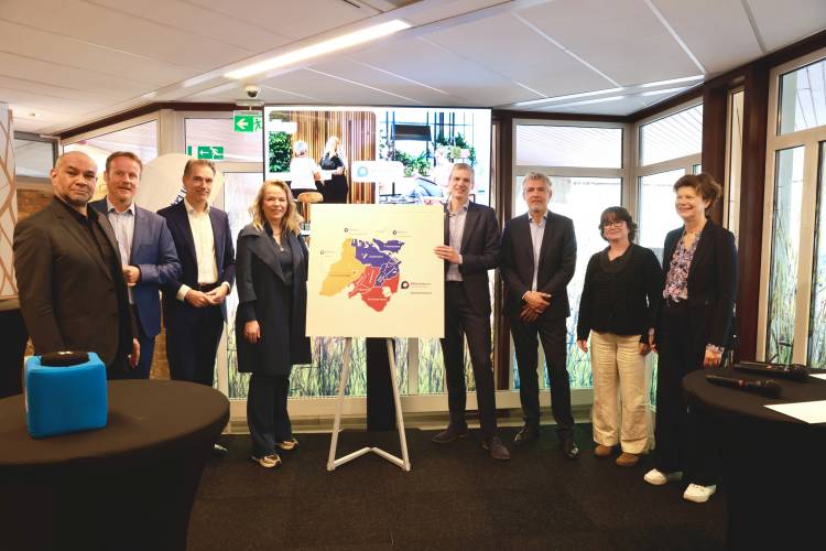 Betrokkenen bij de opening van het Werkcentrum Amstel-Venen staan rondom een bord met daarop een plattegrond van het werkgebied.