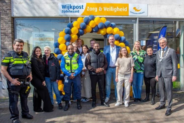 Burgemeester Heiligers staat samen met een aantal medewerkers van andere organisaties voor de ingang van de nieuwe wijkpost Zijdelwaard.