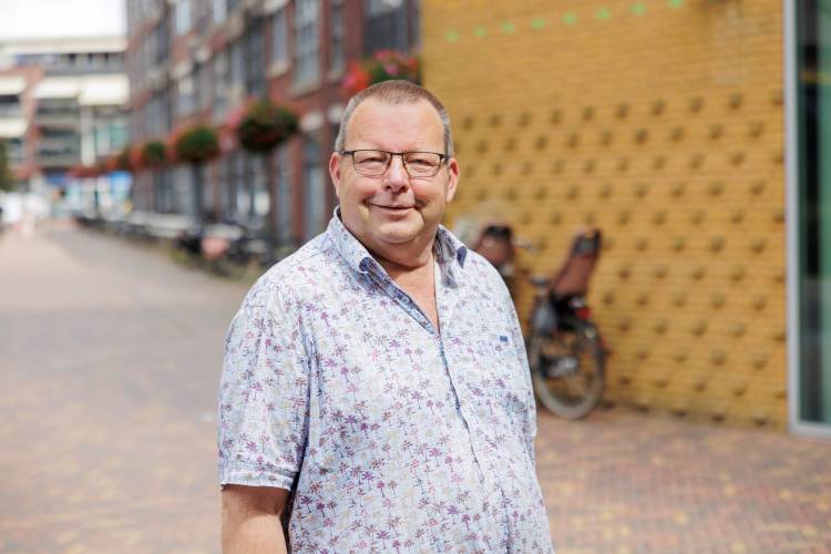 Theo poseert voor een gebouw