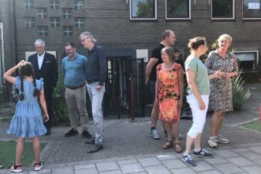 Wethouder Govert van Bezooijen, bestuurder van Stichting Fluvium Pim Spijker en directeur van de nieuwkomersschool Daniel Koelink staan buiten en praten met leerlingen 