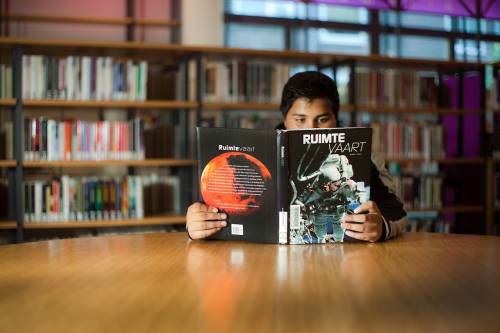 jongen leest boek over ruimtevaart
