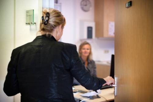 Foto: Vrouw opent deur van spreekkamer