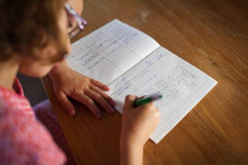 Meisje maakt huiswerk aan tafel