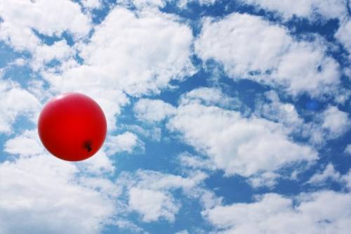 Rode balloon vliegt door de lucht