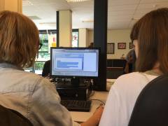 Foto van 2 mensen en een computer