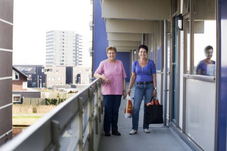 Jongere vrouw helpt buurvrouw met boodschappen
