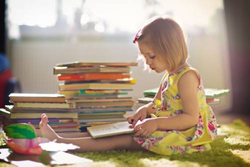 Foto van een kleuter die een boek leest.
