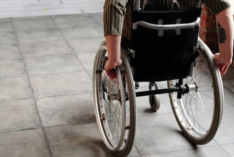 2 armen bedienen een rolstoel