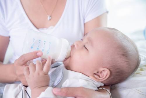Een baby krijgt voeding uit een fles