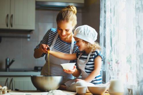 Foto van een moeder die samen met haar dochter aan het koken is