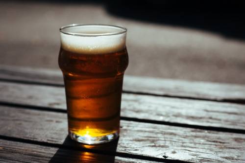 Een glas bier staat op een tafel