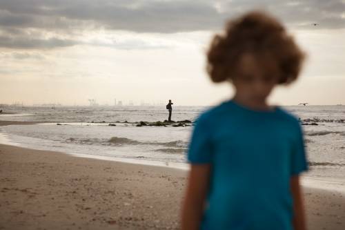 Jongen loopt alleen op het strand
